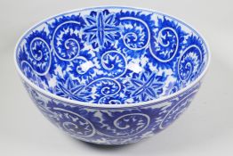 A large blue and white porcelain bowl with scrolling floral decoration, 14" diameter