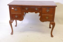 A C19th walnut five drawer kneehole desk, the top with cup corners, raised on cabriole supports with