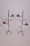 A pair of wrought iron two branch candlesticks, 28" high