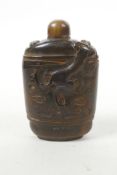 A Chinese horn snuff bottle with carved kylin decoration, 3½" high