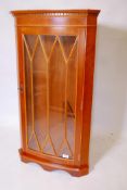 A bowfronted yew wood hanging corner cabinet with astragal glazed door, 22" x 41"