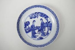 A Chinese blue and white porcelain dish decorated with women in a garden, 6 character mark to