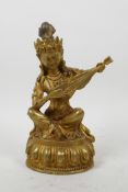 A Sino-Tibetan gilt bronze of a musician on a lotus throne, impressed double vajra mark to base, 8½"