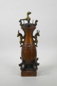 A Chinese coppered and gilt metal vase and cover decorated with dragons, buffalo, birds and