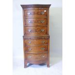 A walnut serpentine front tall boy chest of six drawers, with brushing slide and brass handles,