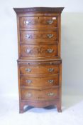 A walnut serpentine front tall boy chest of six drawers, with brushing slide and brass handles,