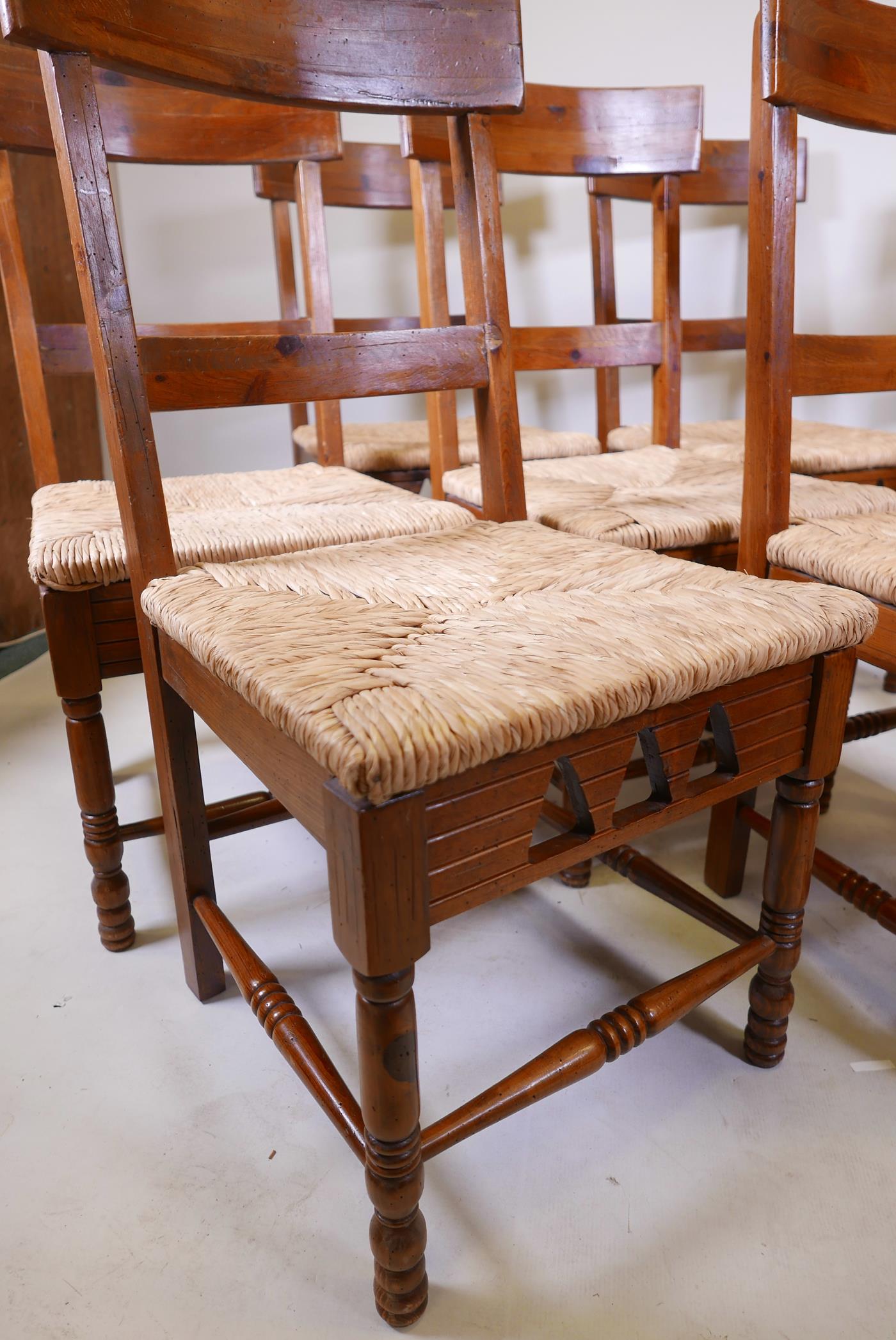 A set of eight rush seated fruitwood chairs with applied Dixy maker's plaque - Image 2 of 3