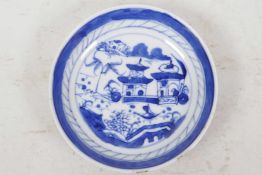 A small Chinese blue and white porcelain dish decorated with pagodas and trees by a lake