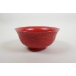 A Chinese red ground porcelain rice bowl with raised dragon decoration, impressed seal mark to base,