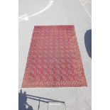 A red ground Turkmen carpet with an all over bokhara design, 81" x 120"