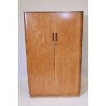 An Art Deco bird's eye maple press cupboard, fitted with shelves, raised on a plinth base, 33" x 23"