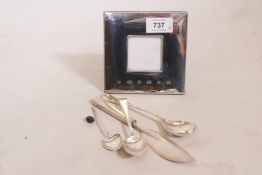 A hallmarked silver 'Concorde' photo frame, a silver strainer, spoons etc