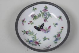 An unusual Chinese porcelain dish painted with butterflies and flowers in an unusual pewter outer