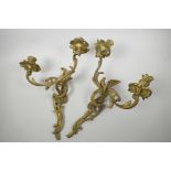 A pair of ormolu two light wall sconces of scrolling leaf design, 17" high