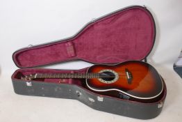 An Ovation electric acoustic guitar with hard carry case, 41" long