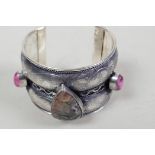 A white metal engraved bangle set with cabochon gemstones