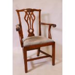 An early C19th walnut Chippendale style elbow chair with pierced and carved splat back, and scroll