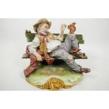 A Capodimonte figure of a scruffy old man sitting on a bench and feeding a squirrel, with birds