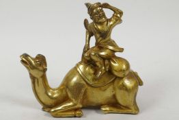 A Sino-Tibetan gilt bronze figure of a trader seated on a camel, 6" high