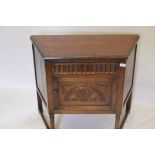 An oak credence cupboard, with single drawer over door and carved decoration, raised on turned