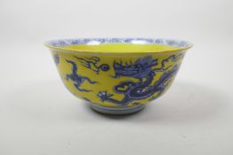 A Chinese yellow ground porcelain bowl with blue and white dragon and flaming pearl decoration, 6