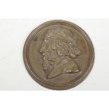 An unusual circular bronze plaque depicting a bearded man with three hidden erotic nude figures