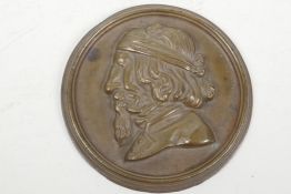 An unusual circular bronze plaque depicting a bearded man with three hidden erotic nude figures