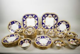 An early C20th Cauldon China tea service, with cobalt blue borders, decorated with gilded oak leaves