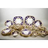 An early C20th Cauldon China tea service, with cobalt blue borders, decorated with gilded oak leaves