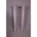 A pair of ribbed wood columns with floral swag bases and acanthus leaf crests, 38½" high
