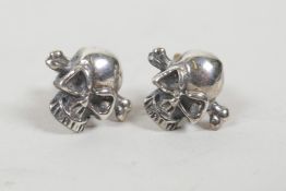 A pair of silver skull ear studs