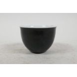 A small Chinese famille noire sake cup painted with all over black glaze and 4 character mark to