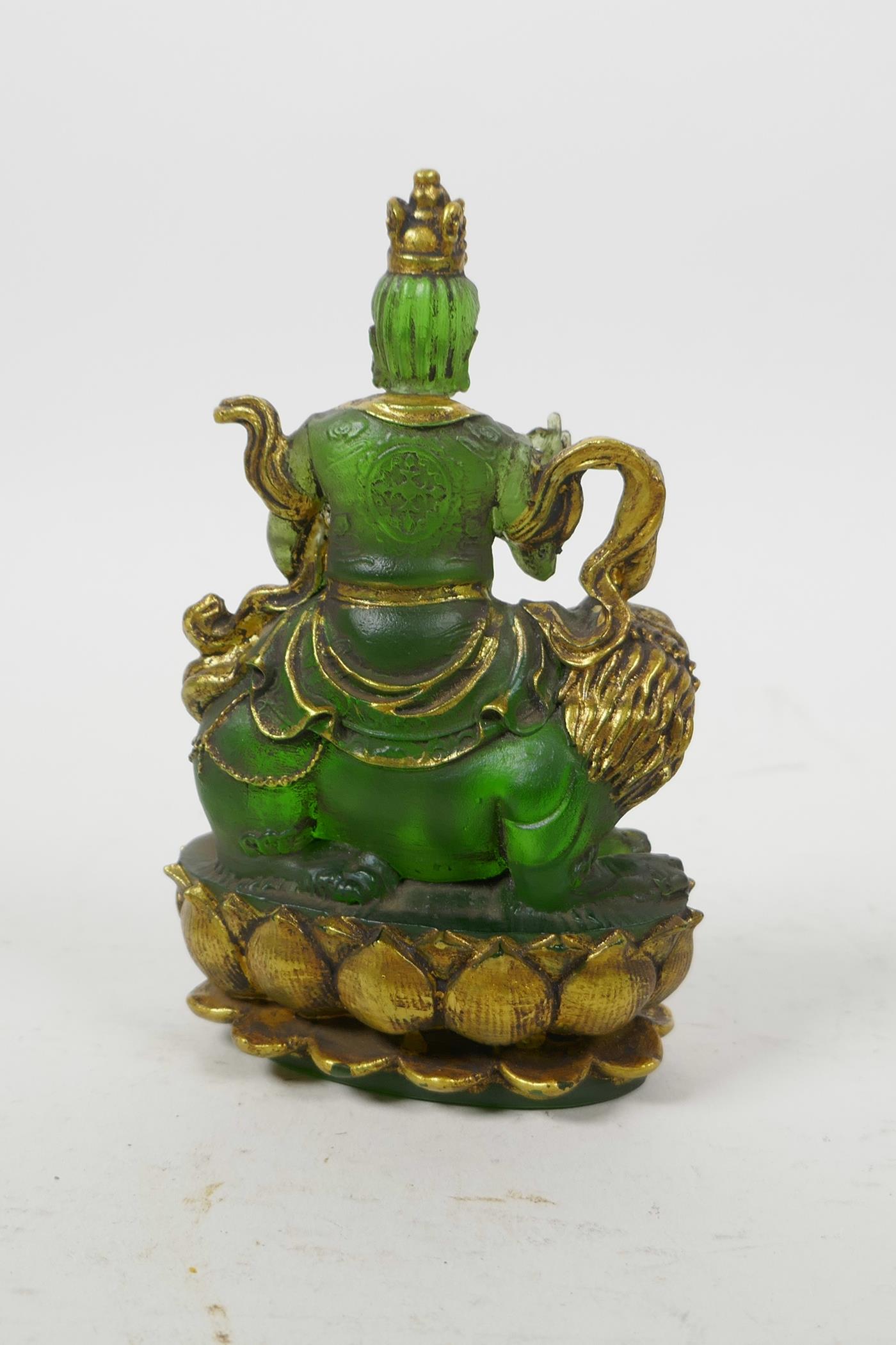 A Tibetan pressed green glass figure of a wrathful deity sitting on a temple lion, 5" high - Image 2 of 3