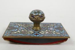 A C19th champleve enamelled desk blotter with ornate floral decoration, 5" x 2¾"