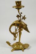 An Oriental polished brass candlestick cast as a stork on a mythical tortoise, 11" high