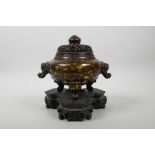 A Chinese bronze censer and pierced cover on tripod supports, with two elephant mask handles and