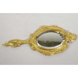 A gilt metal rococo style hand mirror with oval bevelled glass plate, 12" long