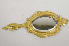 A gilt metal rococo style hand mirror with oval bevelled glass plate, 12" long