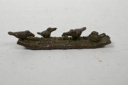 An Oriental bronzed metal incense stick holder in the form of a raft with birds, 4" long