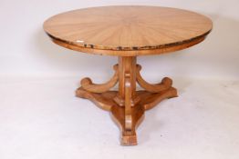 A C19th Biedermeier style tilt top satinwood breakfast table, raised on a hexagonal column with