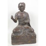 A bronze figure of a bearded Buddhist seated in meditation with splash gilt highlights, 10" high
