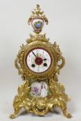 A rococo style ormolu mantel clock with porcelain dial and figurative porcelain panel painted with a