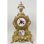 A rococo style ormolu mantel clock with porcelain dial and figurative porcelain panel painted with a