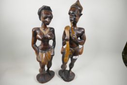 A pair of African carved wood figures of a man and woman, the man smoking a pipe, largest 21½" high