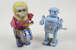 A Chinese tin plate walking toy robot, 5" high, together with a dressed plastic musical monkey