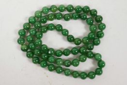 A string of green jade beads, 32" long