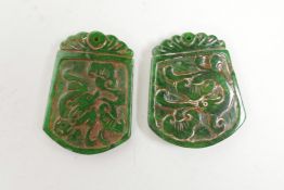 Two Chinese carved green jade pendants with stylised dragon decoration, 1½" x 2"