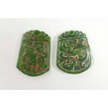 Two Chinese carved green jade pendants with stylised dragon decoration, 1½" x 2"