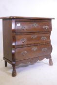 An oak Dutch style bombe fronted three drawer chest, with shaped top, raised on carved supports, 26"