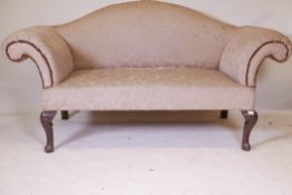 A Georgian camel back settee, with scroll arms, raised on cabriole supports with scroll feet,